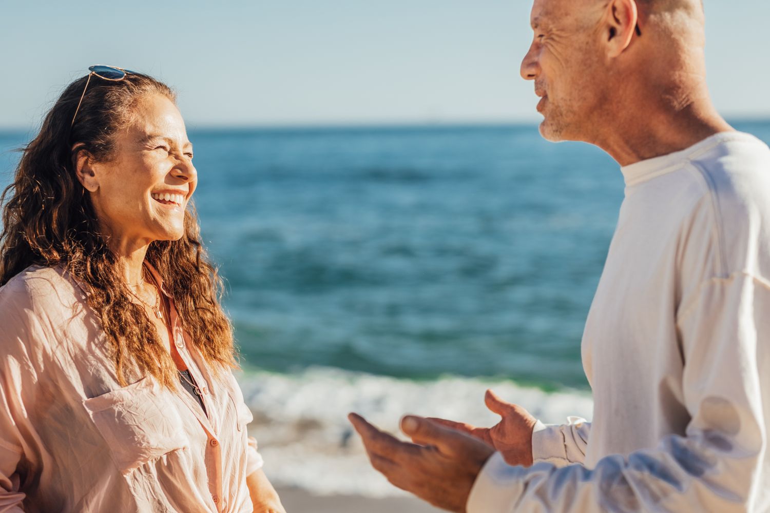 A man and woman sharing a conversation by the ocean